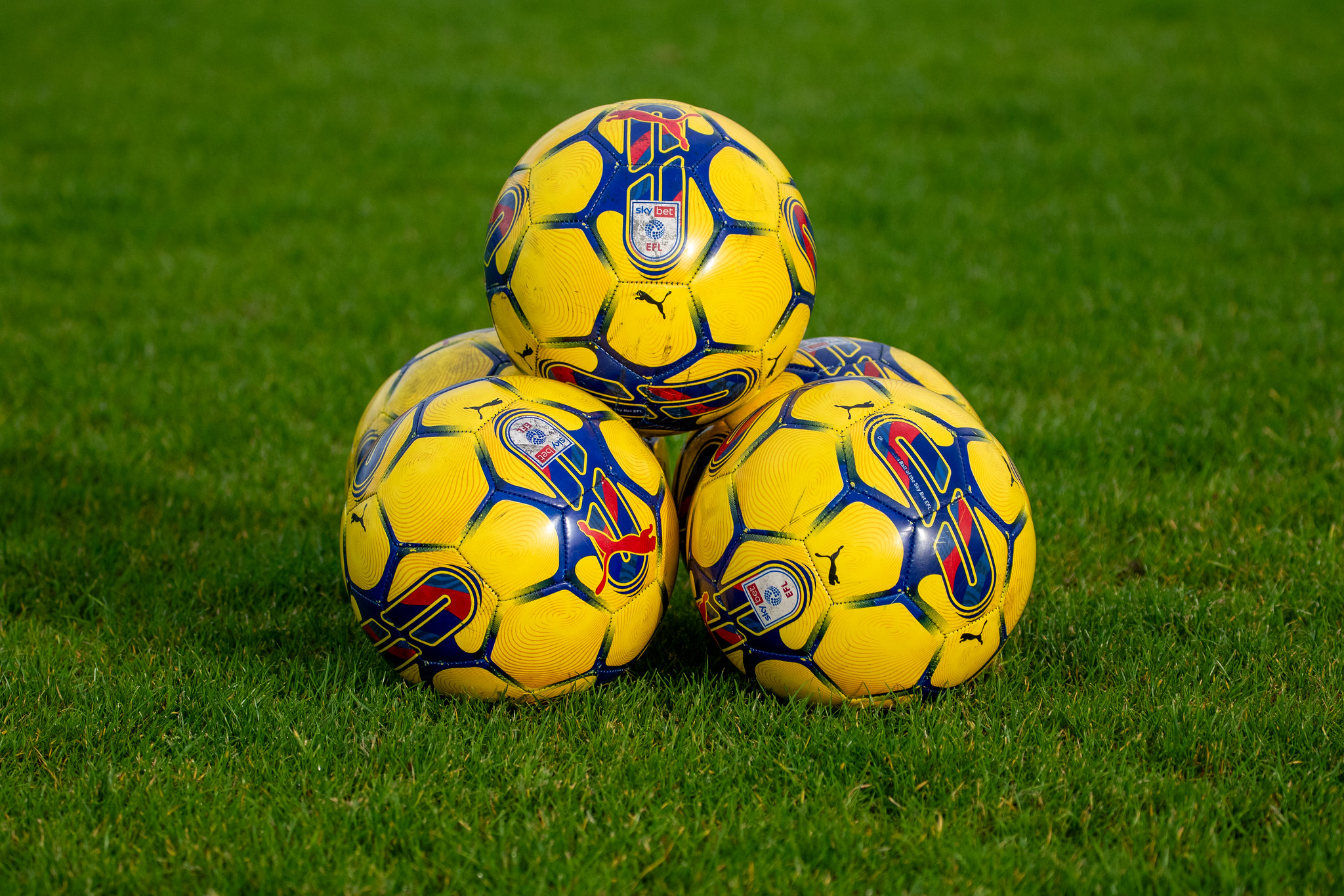 Yellow footballs stacked on a field